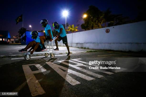 Brazilian bobsledders Rafael Souza, Gustavo Ferreira and Edson Martins play with a trolley in a parking lot of a supermarket on May 20, 2021 in Sao...