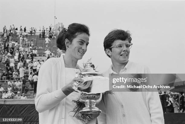 British tennis player Virginia Wade, holding the trophy, alongside American tennis player Billie Jean King, during the presentation ceremony...