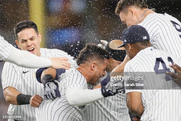 Aaron Judge, Miguel Andujar, and Gio Urshela celebrate with Gleyber Torres of the New York Yankees after his walk-off RBI single during the ninth...