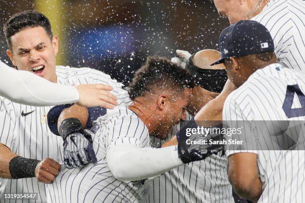 Aaron Judge, Miguel Andujar, and Gio Urshela celebrate with Gleyber Torres of the New York Yankees after his walk-off RBI single during the ninth...