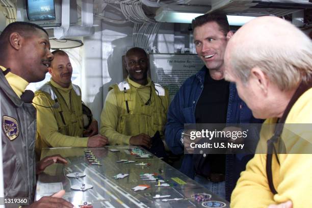Network television sportscasters Howie Long, second right, and Terry Bradshaw, right, autograph ballcaps for sailors in Flight Deck Control December...