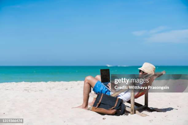 happy business man with laptop working on the beach - generation y arbeit stock-fotos und bilder