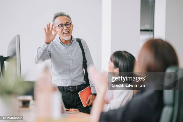 working asian chinese senior colleague back to work with face mask greeting on each other in office morning - hi imagens e fotografias de stock