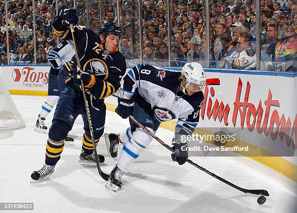 Luke Adam of the Buffalo Sabres defends against Alexander Burmistrov of the Winnipeg Jets during their NHL game at First Niagara Center November 8,...