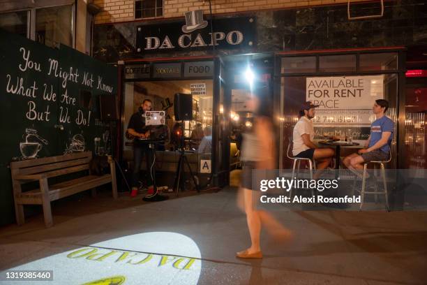 People sit at an outdoor table next to a DJ at Da Capo restaurant on the Upper West Side amid the coronavirus pandemic on May 21, 2021 in New York...