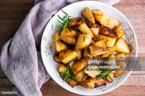 roasted potatoes with rosemary top view - prepared potato stock-fotos und bilder