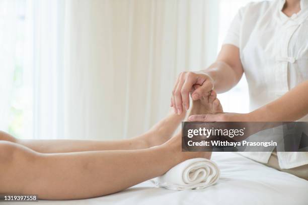 close-up of female hands doing foot massage - reflexology stock-fotos und bilder