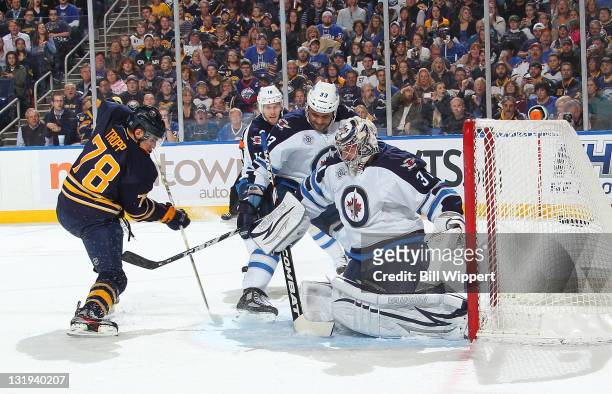 Corey Tropp of the Buffalo Sabres scores his first NHL goal against Dustin Byfuglien and Ondrej Pavelec of the Winnipeg Jets at First Niagara Center...