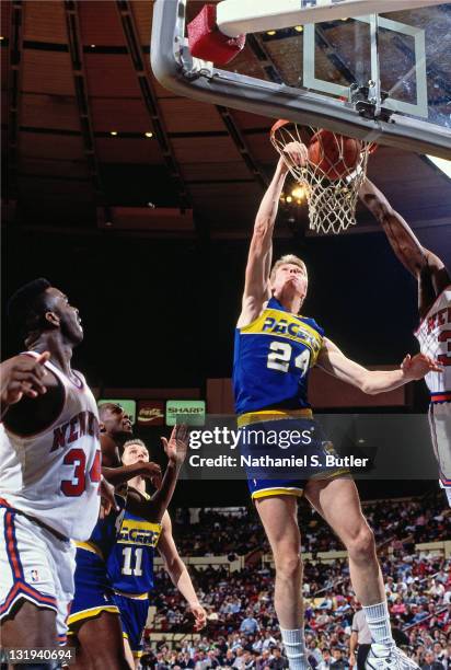 Rik Smits of the Indiana Pacers dunks against Patrick Ewing of the New York Knicks circa 1989 at Madison Square Garden in New York City . NOTE TO...