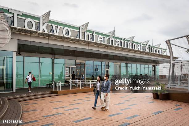 People wearing face masks walk through an observation area at Haneda Airport on May 22, 2021 in Tokyo, Japan. The Japanese government recently...