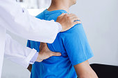 Male doctor therapist working examining treating injured back.Back pain patient, treatment, medical doctor,massage for back pain relief office syndrome.