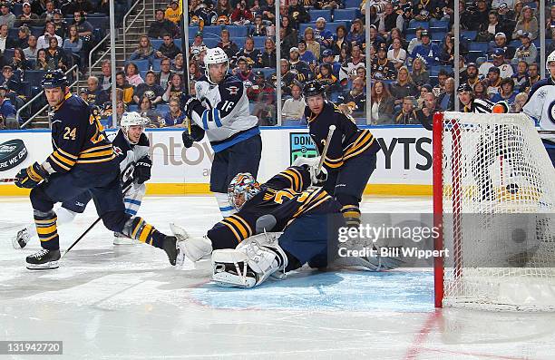 Bryan Little of the Winnipeg Jets scores a second-period goal as teammate Andrew Ladd looks on against Ryan Miller and Robyn Regehr of the Buffalo...