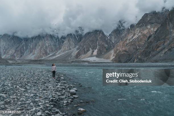 woman standing near the river on the background of mountains - pakistan stock pictures, royalty-free photos & images