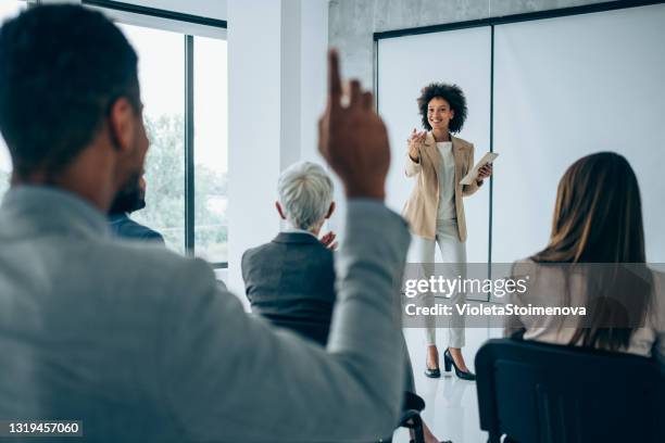 back view of a businessman wants to ask a question on a seminar. - questions answered stock pictures, royalty-free photos & images