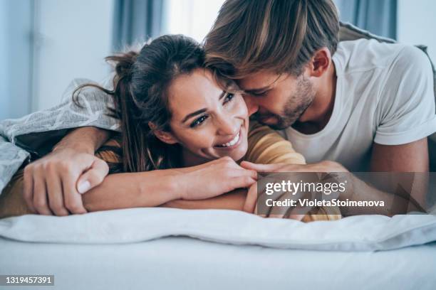paar entspannen im schlafzimmer. - man and woman cuddling in bed stock-fotos und bilder