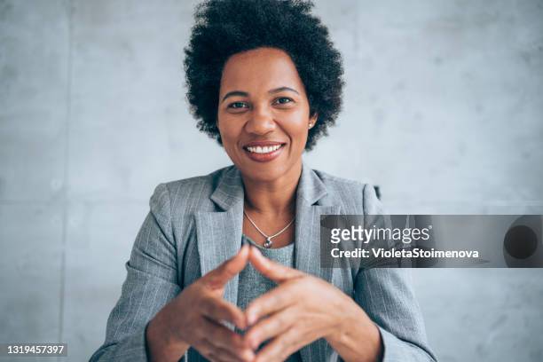 onderneemster die tijdens videogesprek in het bureau spreekt. - african american businesswoman isolated stockfoto's en -beelden