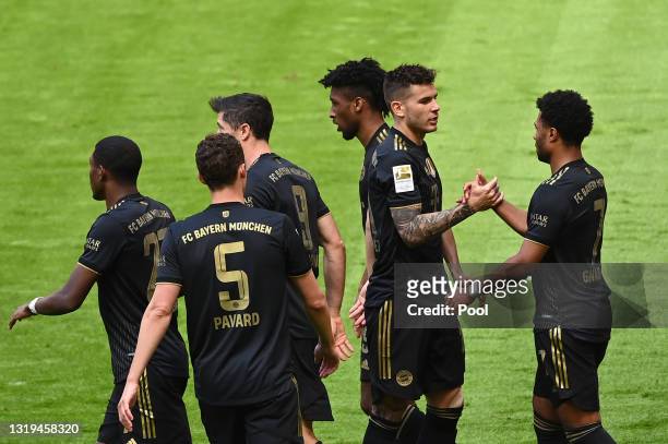 Kingsley Coman of FC Bayern Muenchen celebrates with team mates after scoring their side's first goal during the Bundesliga match between FC Bayern...