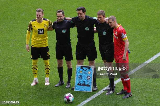 Lukasz Piszczek of Borussia Dortmund, Sven Bender of Bayer Leverkusen and Manuel Grafe, the match referee posing for a photo due to it being all of...