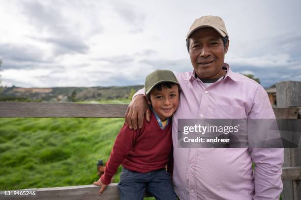 liebende lateinamerikanische vater und sohn sieht glücklich auf einem bauernhof - boys in countryside stock-fotos und bilder