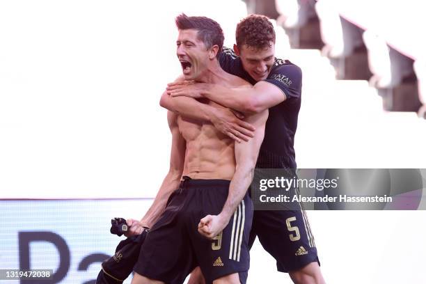 Robert Lewandowski of FC Bayern Muenchen celebrates with team mate Benjamin Pavard after scoring their side's fifth goal, scoring his 41st league...