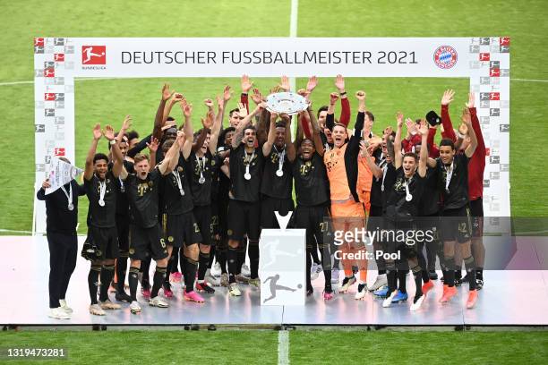 Javier Martinez, David Alaba and Jerome Boateng of FC Bayern Muenchen lift the Bundesliga Meisterschale Trophy following the Bundesliga match between...