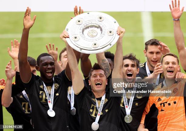 Robert Lewandowski of FC Bayern Muenchen lifts the Bundesliga Meisterschale Trophy in celebration with team mates following the Bundesliga match...