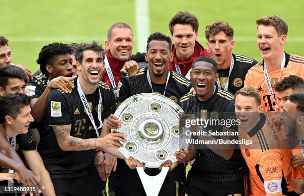 Javier Martinez, David Alaba and Jerome Boateng of FC Bayern Muenchen lift the Bundesliga Meisterschale Trophy following the Bundesliga match between...