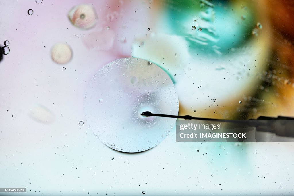 Injecting cell with needle through microscope