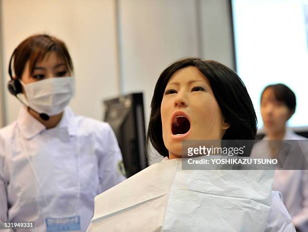 Nippon Dental University Hospital staff member demonstrates a humanoid robot dental therapy simulator named "Simroid" at the International Robot...