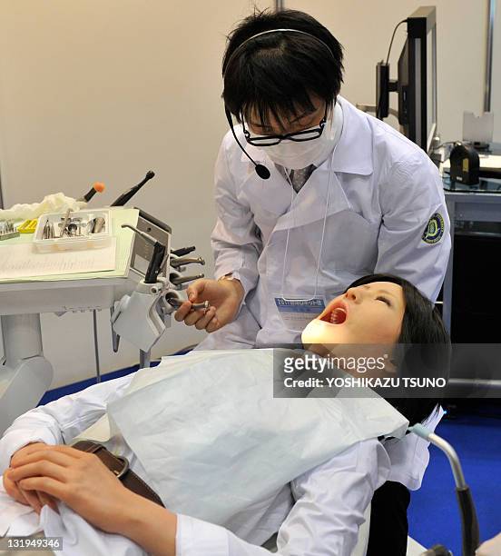 Nippon Dental University Hospital staff member demonstrates a humanoid robot dental therapy simulator named "Simroid" at the International Robot...