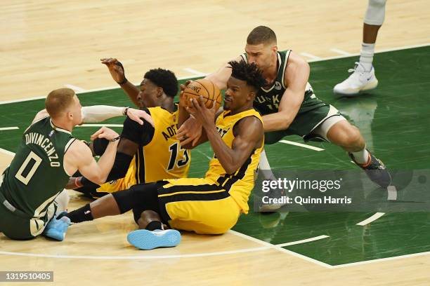 Jimmy Butler of the Miami Heat and Brook Lopez of the Milwaukee Bucks battle for the ball in the fourth quarter during Game 1 of their Eastern...