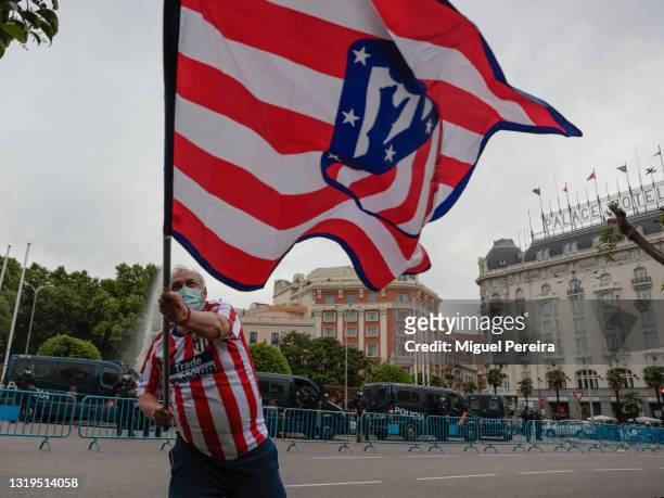 Man carrying a large flag celebrates Atlético de Madrid winning La Liga at Neptuno Square on May 22 in Madrid, Spain.