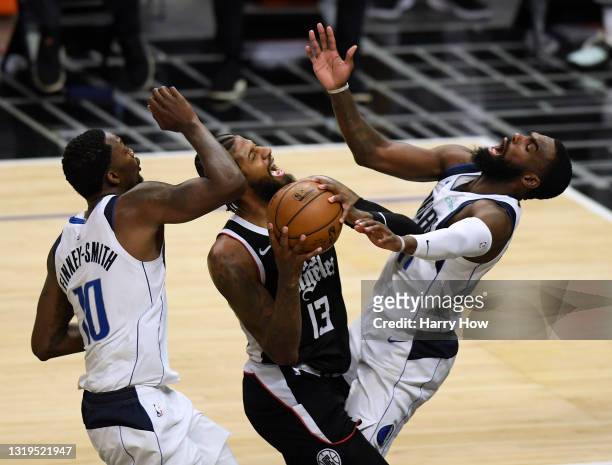 Paul George of the LA Clippers reacts as he is called for an offensive foul as he drives to the basket between Dorian Finney-Smith and Tim Hardaway...