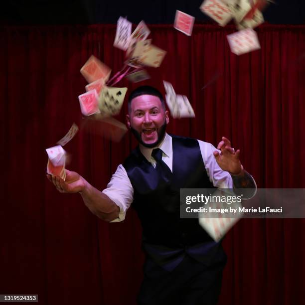 magician throwing playing cards in the air - goochelshow stockfoto's en -beelden