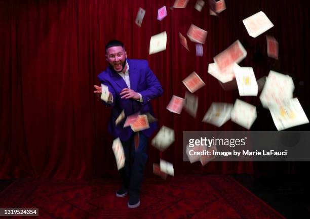 magician on stage throwing playing cards in the air - goochelshow stockfoto's en -beelden