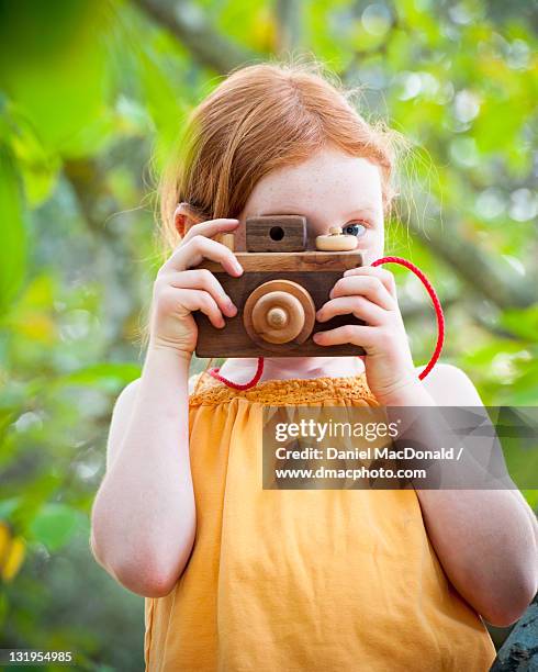 young girl taking picture with wooden toy camera - toy camera stock pictures, royalty-free photos & images