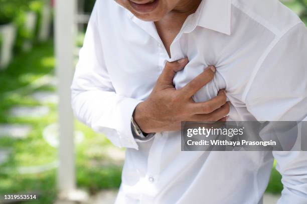 man clutching his chest from acute pain.heart attack symptom-healthcare and medical concept. - black man heart attack stock pictures, royalty-free photos & images