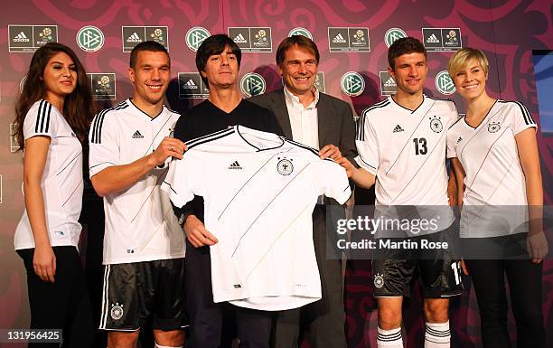 Lukas Podolski, Joachim Loew, Guenter Weigl of adidas and Thomas Mueller pose with the Jersey during the Germany national team Euro 2012 jersey...