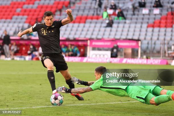 Robert Lewandowski of FC Bayern Muenchen battles for the ball against Rafal Gikiewicz, keeper of Ausgburg to score their side's fifth goal scoring...