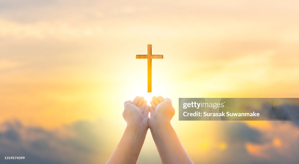 Religion Christ and the cross of Jesus Christ at sunset, golden light.