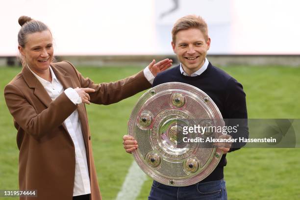 Bastian Wernscheid, team manager of FC Bayern München lifts the Bundesliga Meisterschale Trophy next to Kathleen Krüger of FC Bayern München after...