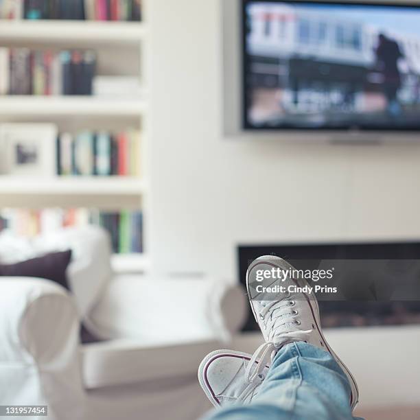 relaxing at home, watching tv - feet up - fotografias e filmes do acervo