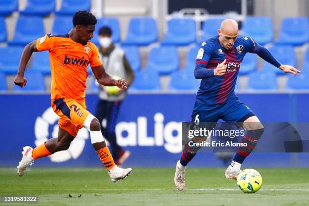 Sandro Ramirez of SD Huesca challenges for the ball against Thierry Correia of Valencia CF during the La Liga Santander match between SD Huesca and...