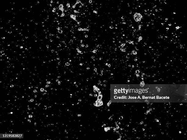 moving water drops and splashes on a black background. - drop of water stock pictures, royalty-free photos & images