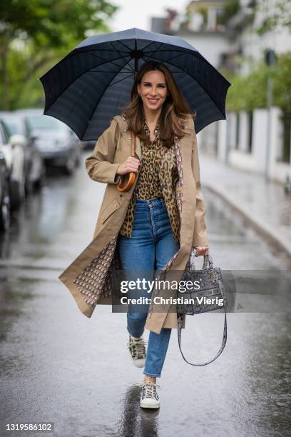 Alexandra Lapp is seen with an umbrella wearing CHRISTIAN DIOR Hooded Coat in beige, CHRISTIAN DIOR animal print silken Mizza Bar Jacket, CHRISTIAN...