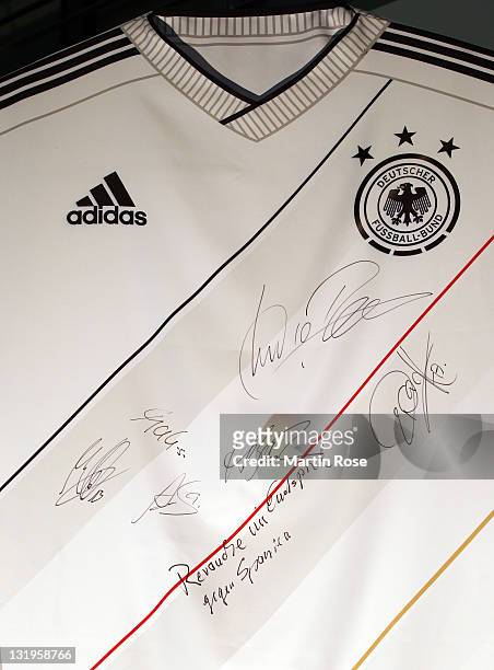 Players signed autographs on a jersey model after the Germany national team Euro 2012 jersey launch at Mercedes Benz Center on November 9, 2011 in...