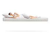 Young woman in white pajamas sleeping on a floating mattress