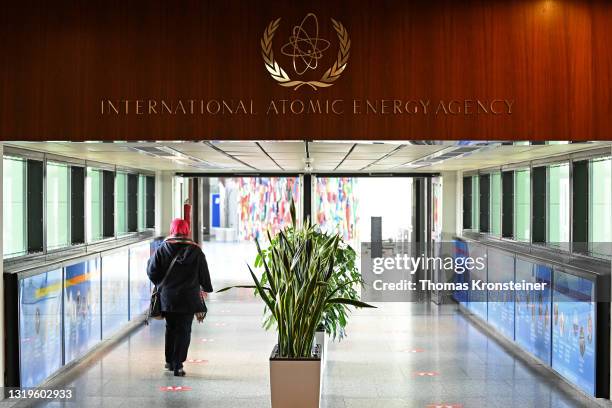 Woman walks past the sign of the International Atomic Energy Agency ahead of a press conference by Rafael Grossi, Director General of the IAEA, about...