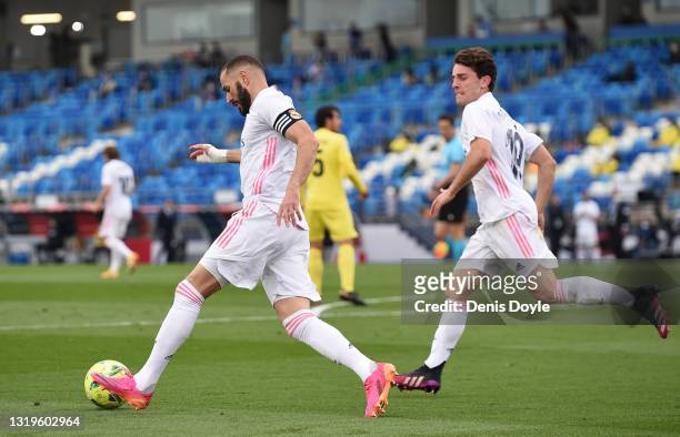 Karim Benzema of Real Madrid plays the ball back to the semi-circle after scoring their side's first goal during the La Liga Santander match between...