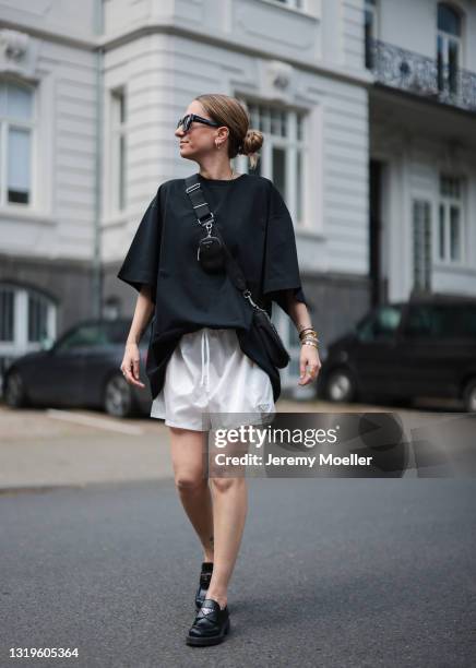 Michi Brandl wearing white Prada shorts, black oversized Vival studios shirt, black Prada nylon bag, black Prada loafers and Kapten & Son shades on...
